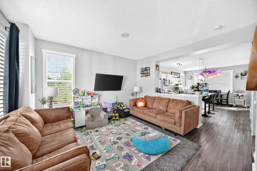 Open-concept living area featuring light gray wall tones, wood-finish flooring, and recessed lighting - 1929 24 Street Nw, Edmonton, AB - Indoor Photo Showing Living Room
