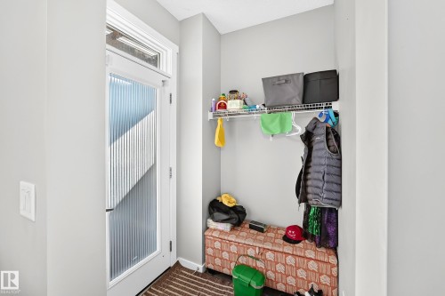Entryway featuring a white door with reeded glass, a transom window, and an integrated wire shelving system - 1929 24 Street Nw, Edmonton, AB - Indoor Photo Showing Other Room