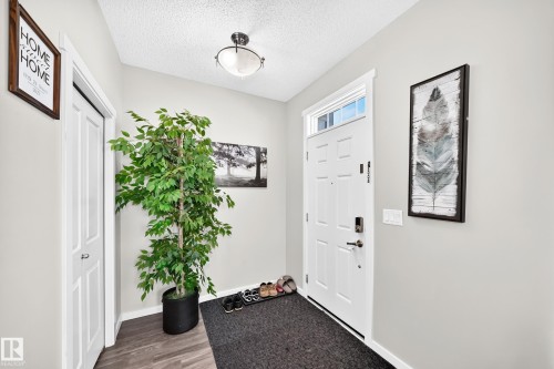 Bright entryway featuring wood-finish flooring, white six-panel entry door with hardware, recessed ceiling lighting, and framed wall art - 1929 24 Street Nw, Edmonton, AB - Indoor Photo Showing Other Room