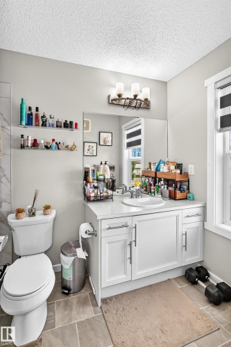 Vanity with white shaker-style cabinetry, a white countertop, and an undermount sink - 1929 24 Street Nw, Edmonton, AB - Indoor Photo Showing Bathroom