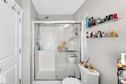 Shower enclosure with glass sliding doors and white base - 1929 24 Street Nw, Edmonton, AB - Indoor Photo Showing Bathroom