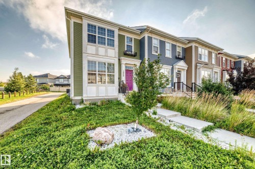 Contemporary townhome exterior with varied siding, a distinct purple entry door, and multi-pane windows - 1929 24 Street Nw, Edmonton, AB - Outdoor With Facade