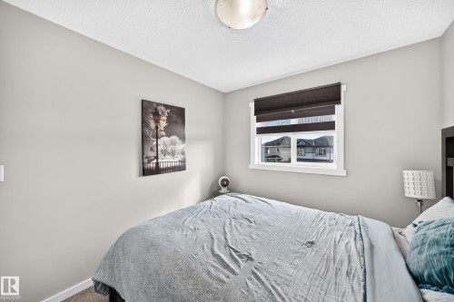 Neutral wall color, window with dark-toned roller shades, and overhead lighting fixture - 1929 24 Street Nw, Edmonton, AB - Indoor Photo Showing Bedroom