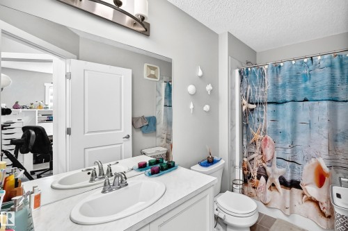 Dual vanity with undermount sinks, chrome fixtures, and an extended mirror - 1929 24 Street Nw, Edmonton, AB - Indoor Photo Showing Bathroom