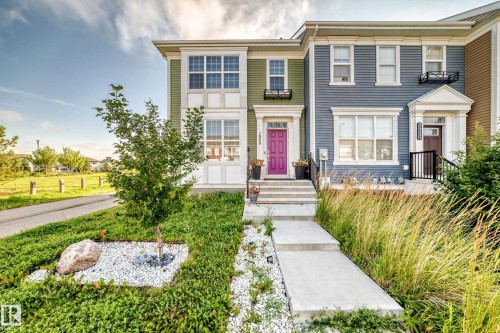 Green siding exterior with a bright purple entry door, white trim accents, and a concrete walkway - 1929 24 Street Nw, Edmonton, AB - Outdoor With Facade