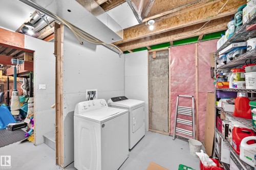 Laundry area featuring a washer and dryer, exposed ceiling joists, and partial drywall - 1929 24 Street Nw, Edmonton, AB - Indoor Photo Showing Laundry Room
