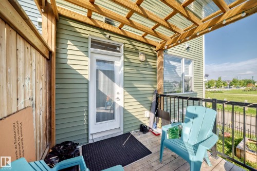 Deck featuring a wood pergola with clear roofing panels, wood-finish flooring, and black metal railings - 1929 24 Street Nw, Edmonton, AB - Outdoor With Deck Patio Veranda With Exterior