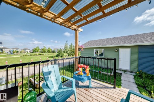 Wood-finish deck with black metal railings, covered by a wood pergola with a translucent roof - 1929 24 Street Nw, Edmonton, AB - Outdoor With Deck Patio Veranda With Exterior