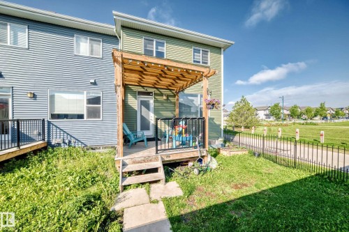 Private deck with pergola, black metal railings, and concrete step entry, bordered by a fenced yard - 1929 24 Street Nw, Edmonton, AB - Outdoor With Deck Patio Veranda With Exterior