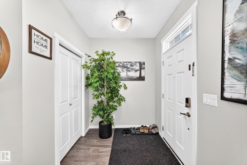 Entryway with wood-finish flooring, white paneled door, and transom window - 1929 24 Street Nw, Edmonton, AB - Indoor Photo Showing Other Room