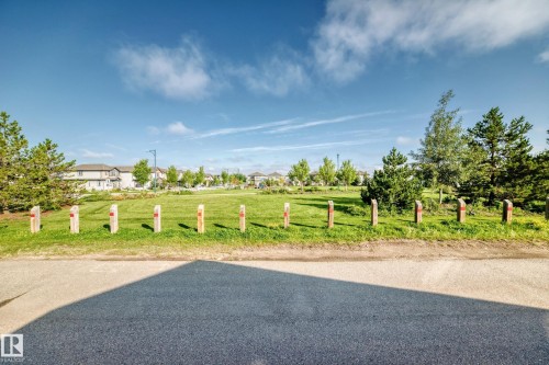 Expansive green space featuring mature trees and a manicured lawn - 1929 24 Street Nw, Edmonton, AB - Outdoor With View