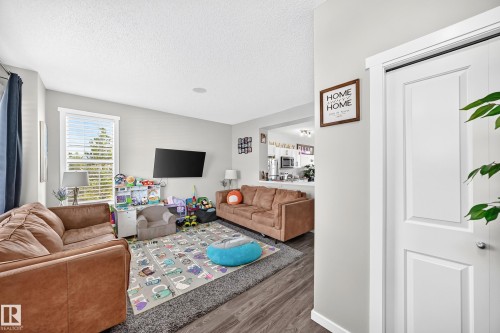 Recessed ceiling lighting, wood-finish flooring, white window blinds, and interior doors with white trim - 1929 24 Street Nw, Edmonton, AB - Indoor Photo Showing Living Room