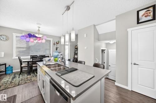 Modern kitchen island with stainless steel double sink and integrated dishwasher - 1929 24 Street Nw, Edmonton, AB - Indoor Photo Showing Kitchen With Double Sink