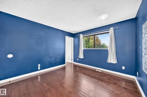Wood-finish flooring with a smooth white ceiling - 16808 100 Street Nw, Edmonton, AB - Indoor Photo Showing Other Room