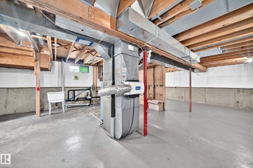 Open unfinished basement featuring concrete walls and flooring, exposed wood ceiling joists, and a utility sink - 16808 100 Street Nw, Edmonton, AB - Indoor Photo Showing Basement