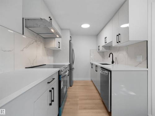 Contemporary kitchen featuring white cabinetry, quartz countertops, a stone-finish backsplash, and stainless steel appliances - 126 Woodstock Nw, Edmonton, AB - Indoor Photo Showing Kitchen With Upgraded Kitchen