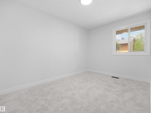 White walls and light grey carpeting, featuring a single window with white trim, and a flush-mount ceiling light - 126 Woodstock Nw, Edmonton, AB - Indoor Photo Showing Other Room