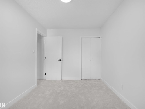 Light-toned carpeting and white walls - 126 Woodstock Nw, Edmonton, AB - Indoor Photo Showing Other Room
