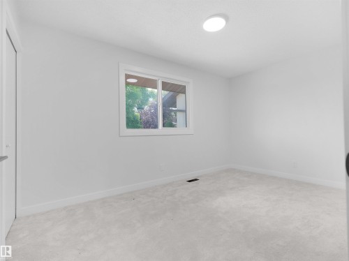 Light-colored carpeting, white painted walls, and a single window with white trim - 126 Woodstock Nw, Edmonton, AB - Indoor Photo Showing Other Room