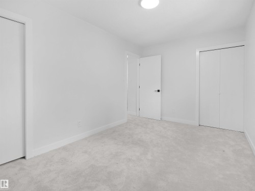 Neutral tone carpeting, white walls, and a flush-mount ceiling light - 126 Woodstock Nw, Edmonton, AB - Indoor Photo Showing Other Room