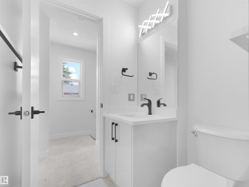 White vanity with a solid surface countertop and matte black fixtures - 126 Woodstock Nw, Edmonton, AB - Indoor Photo Showing Bathroom