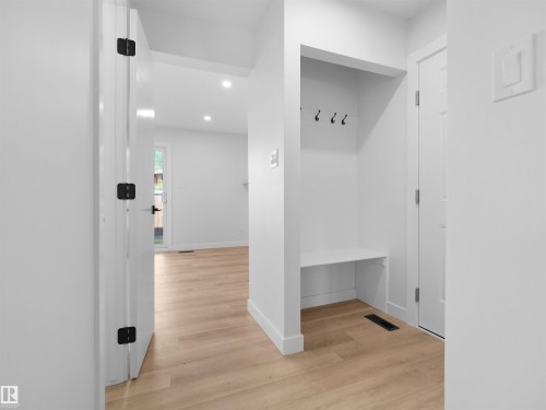 Recessed lighting, wood-finish flooring, built-in bench, and black door hardware - 126 Woodstock Nw, Edmonton, AB - Indoor Photo Showing Other Room