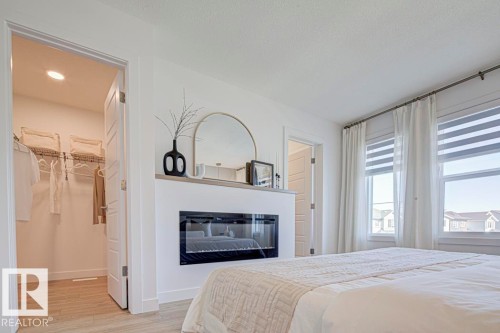 4550 Warbler Loop Nw, Edmonton, AB - Indoor Photo Showing Bedroom With Fireplace