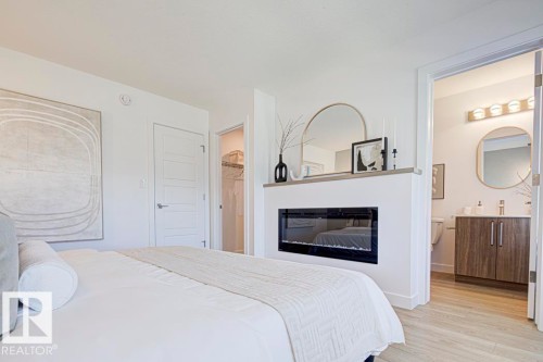 4550 Warbler Loop Nw, Edmonton, AB - Indoor Photo Showing Bedroom With Fireplace