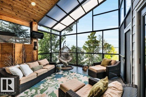 This screened area with an overhead heater and roll down blind will soon be your favorite area of the home to relax! - 180 Crystal Springs Drive, Rural Wetaskiwin County, AB - 