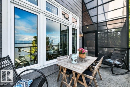 Expansive deck with a textured surface, full-height windows, and a screened enclosure - 180 Crystal Springs Drive, Rural Wetaskiwin County, AB -  With Exterior