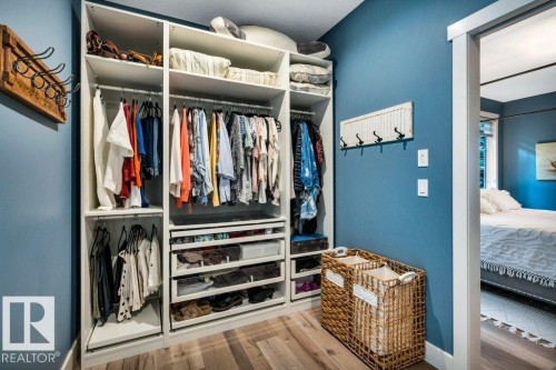 Integrated custom closet system with varied shelving, multiple hanging rods, and pull-out drawers - 180 Crystal Springs Drive, Rural Wetaskiwin County, AB - Indoor With Storage