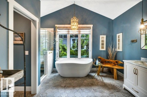 Freestanding soaking tub, enclosed shower, double vanity with a marble-finish countertop, and stunning tiles in muted tones - 180 Crystal Springs Drive, Rural Wetaskiwin County, AB - Indoor Photo Showing Bathroom