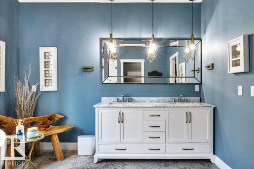 Double vanity with stone countertop, dual undermount sinks, and wall-mounted mirror - 180 Crystal Springs Drive, Rural Wetaskiwin County, AB - Indoor Photo Showing Bathroom