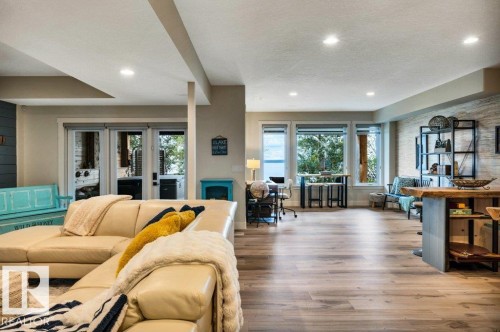 Walkout lower level family room offers Recessed lighting, wood-finish flooring, full-light French doors, multiple windows - 180 Crystal Springs Drive, Rural Wetaskiwin County, AB - Indoor Photo Showing Living Room