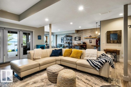 Spacious living area featuring wood-finish flooring, recessed lighting, and direct outdoor access via French doors to the hot tub - 180 Crystal Springs Drive, Rural Wetaskiwin County, AB - Indoor Photo Showing Living Room
