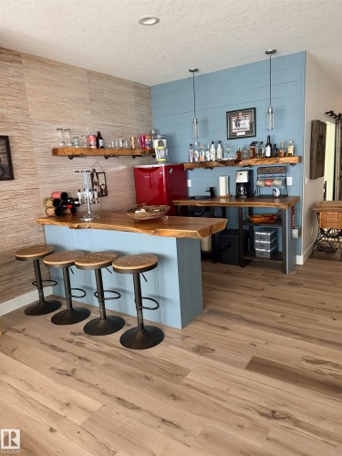 Live-edge wood bar and counter with textured accent wall - 180 Crystal Springs Drive, Rural Wetaskiwin County, AB - Indoor