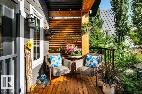 Wood-finish decking, horizontal wood privacy screen, black metal railing, and wood-sided exterior - 180 Crystal Springs Drive, Rural Wetaskiwin County, AB - Outdoor With Exterior