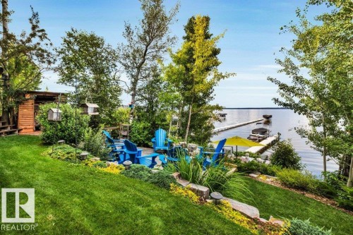 Multi level terracing showcases a Manicured lawn area, mature trees and a stone-edged garden bed - 180 Crystal Springs Drive, Rural Wetaskiwin County, AB - Outdoor With View