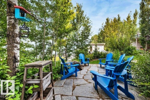 Expansive flagstone patio area with surrounding mature trees and lush plantings on yet another lakeside level! - 180 Crystal Springs Drive, Rural Wetaskiwin County, AB - Outdoor