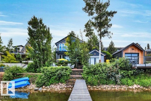 Waterfront property featuring terraced landscaping, and multiple outdoor living spaces - 180 Crystal Springs Drive, Rural Wetaskiwin County, AB - Outdoor With Body Of Water