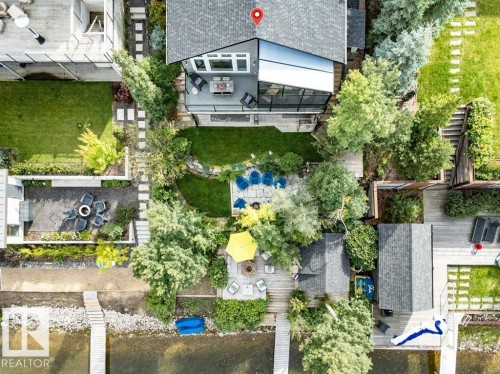 Expansive waterfront property featuring multiple private docks, terraced landscaping with stepping stone paths, and a dedicated patio space - 180 Crystal Springs Drive, Rural Wetaskiwin County, AB - Outdoor With Body Of Water
