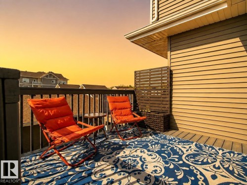 Exterior deck featuring a slatted privacy screen, horizontal siding, and dark railing - 4013 Blackbird Link Nw, Edmonton, AB - Outdoor With Exterior