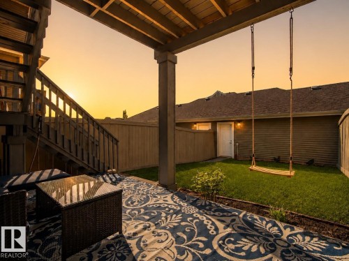 Covered patio with a wood ceiling, wood-plank stairs, and a grassy backyard - 4013 Blackbird Link Nw, Edmonton, AB - Indoor