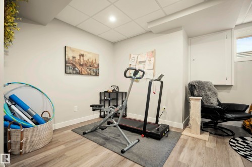 Recessed lighting illuminates wood-finish flooring in this versatile space - 4013 Blackbird Link Nw, Edmonton, AB - Indoor Photo Showing Gym Room
