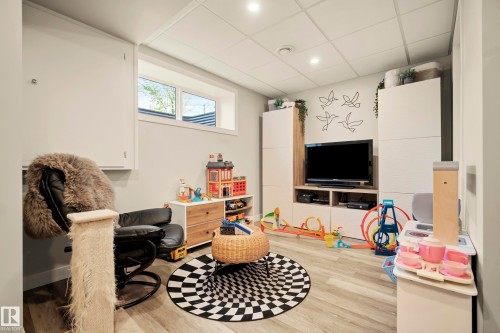 Recessed lighting, drop ceiling, wood-finish flooring, built-in storage units, and a horizontal window - 4013 Blackbird Link Nw, Edmonton, AB - Indoor