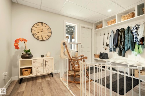 Built-in shelving with coat hooks and storage compartments, wood-finish flooring, and light-toned walls - 4013 Blackbird Link Nw, Edmonton, AB - Indoor Photo Showing Other Room