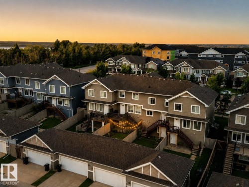 Townhome community with multiple architectural styles, pitched roofs, private garages, and fenced backyards - 4013 Blackbird Link Nw, Edmonton, AB - Outdoor