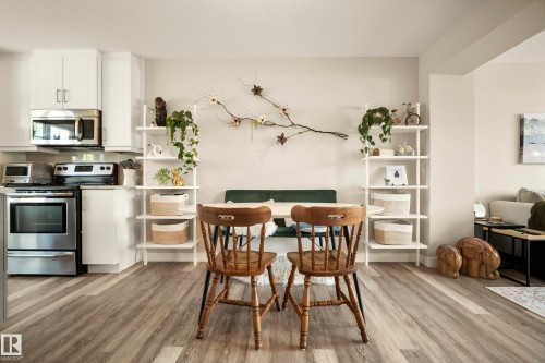 Stainless steel appliances, white cabinetry, wood-finish flooring, built-in shelving, and recessed lighting - 4013 Blackbird Link Nw, Edmonton, AB - Indoor