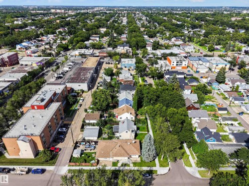 Aerial perspective showcasing a residential area with mature trees, established street patterns, and a mix of single-family homes and multi-story buildings - 9402 117 Avenue Nw, Edmonton, AB - Outdoor With View