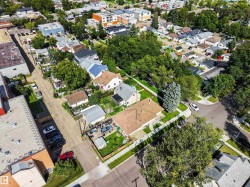 Residential properties with mature trees, paved streets, and concrete sidewalks - 